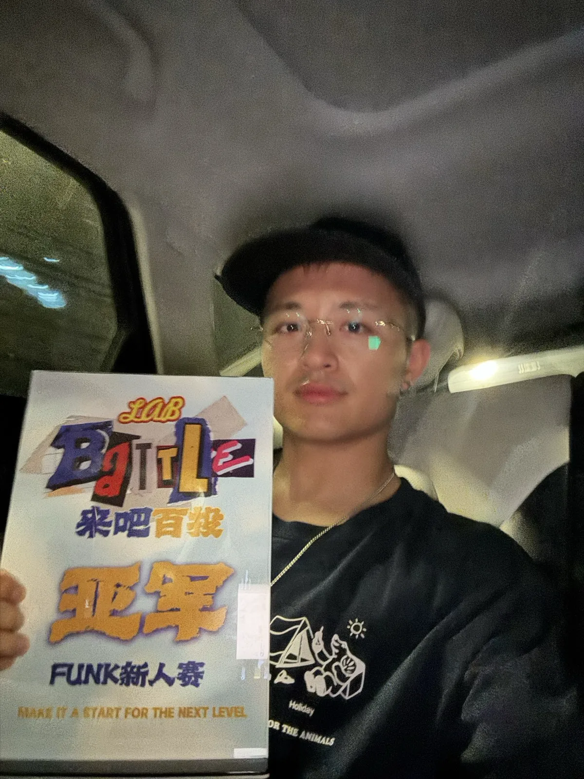 扎飞在车里举着「樂吧百戰 FUNK新人賽 亚军」的奖状